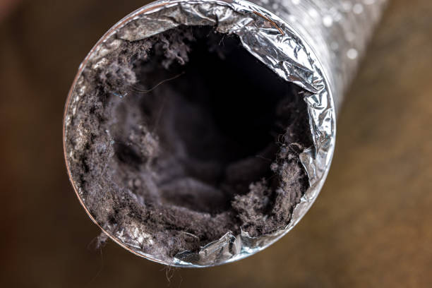 Close-up of a flexible aluminum duct clogged with dust and lint buildup